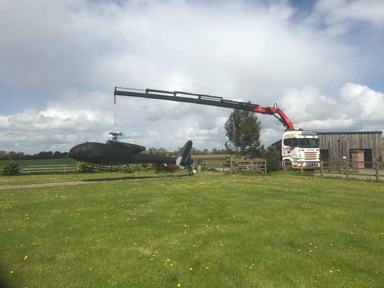 Vehicle lifting a helicopter with mounted crane